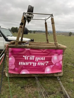 Will you marry me banner on hot air balloon basket